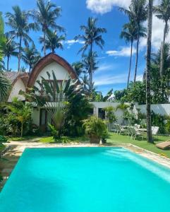 卢纳将军城Tropical Temple Siargao Resort的棕榈树屋前的游泳池