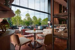 峇六拜槟城国际会展中心阿玛瑞酒店的客房设有桌椅和大窗户。