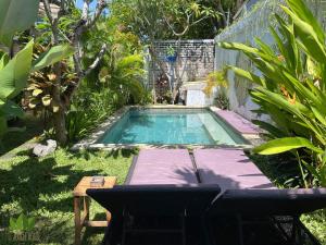 坎古丛林之家旅舍的庭院内的游泳池,配有桌椅