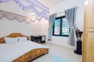 木州县Villa Habit 3br Center Mộc Châu的一间卧室配有一张床、一张书桌和一个窗户。