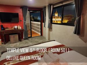 曼谷Lo-Ha Guest house, Contactless Check-in的客房设有一张床和带阳台的窗户。