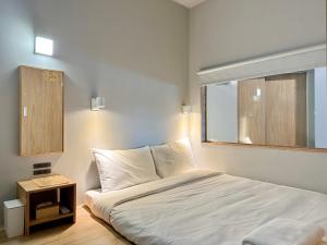 高雄栈贰沐居的卧室配有白色的床和窗户。