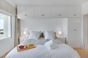 马贝拉Lujoso apartamento con alucinantes vistas al golf - Iwii A 38的一张白色的床,上面有水果盘