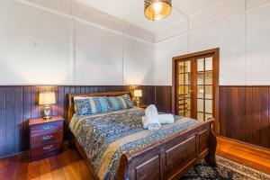 弗里曼特All Decked Out, Fremantle的一间卧室配有一张带木制床头板和一张桌子的床。