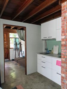 台南复古小屋的一间带白色橱柜的厨房和一间客厅