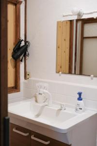一軒家貸切 ARUYOguesthouse BBQと焚き火ができる宿的浴室设有白色水槽和镜子