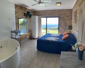 马莱尼Maleny Views Motel的一间卧室配有蓝色的床和浴缸