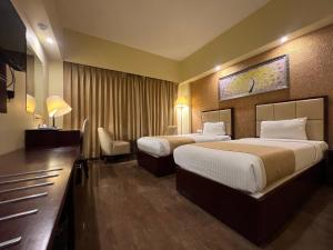 加尔各答O2氧气酒店的酒店客房配有两张床和一张书桌