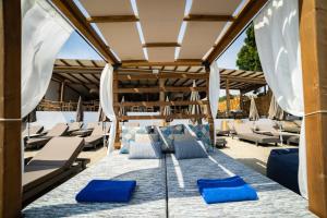 斯基亚索斯镇Skiathos Thalassa, Philian Hotels and Resorts的一个带蓝色躺椅和遮阳伞的庭院