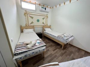 布哈拉Shaxruza Shahzoda Guest House的一间卧室设有两张床,墙上设有一面镜子