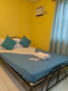 达沃市YellowPad Hotel (SM-Eco)的一张带蓝色枕头的床和毛巾