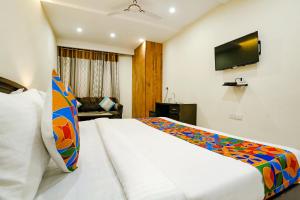 新德里FabHotel F9 NSP的一间酒店客房,配有一张床和一台电视