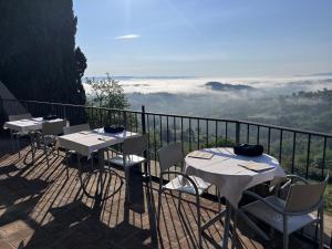 圣吉米纳诺Terra d'Ombra Bed&Breakfast的阳台上摆放着一排桌椅,可欣赏到风景