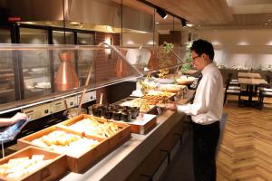 大阪大阪科罗纳酒店的站在厨房准备食物的人