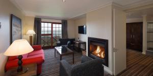 卡利登The Caledon Hotel and Spa的客厅设有壁炉和红色沙发。