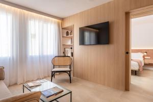 马翁ARTIEM Apartamentos的客厅配有沙发和墙上的电视