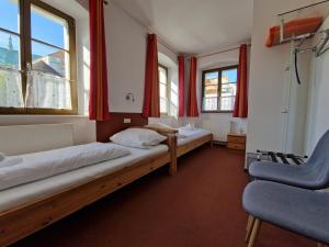 格尔利茨祖姆霍托特伽尼酒店的配有红色窗帘的客房内的两张床