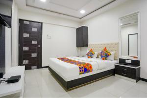 纳威孟买FabExpress Rajmahal的一间卧室配有一张大床和镜子