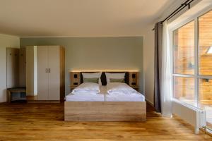 奥斯特巴特宁哈根Landhaus Nienhagen的一间卧室设有一张大床和大窗户
