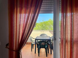 奇克拉纳－德拉弗龙特拉Apartamento Campo de Golf的阳台配有桌椅和窗户