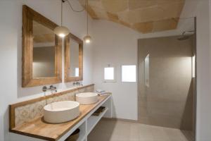 休达德亚Hotel Nou Sant Antoni的一间带两个盥洗盆和淋浴的浴室