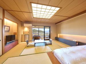 伊豆之国市Fugaku Hanabusa的一间卧室配有一张床和一台电视。
