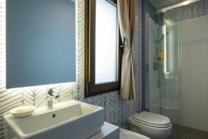里乔内Romagna Family Village Riccione的一间带水槽、卫生间和镜子的浴室