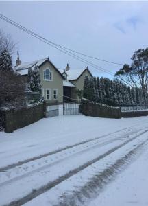 金塞尔clover cottage的一座有栅栏的房子和一个雪覆盖的院子