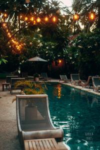 吉利特拉旺安Belukar Villas的度假村内带椅子和灯的游泳池
