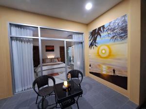 Ban ChamrungPool Villa, Resort, Mae Ramphueng Beach, Ban Phe, Rayong, Residence M Thailand的一间带桌椅的用餐室和一间卧室