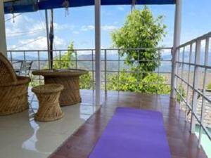LohaghātBuRANSH VILLA的阳台的紫色瑜伽垫