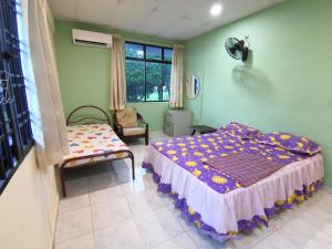 乌鲁地南Cosy Homestay Ulu Tiram的卧室配有床、椅子和窗户。