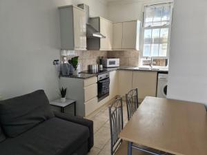 伦敦3 BedRoom Flat*5 Min walk to Kings cross. Netflix的一间配有沙发和桌子的厨房