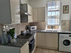 伦敦3 BedRoom Flat*5 Min walk to Kings cross. Netflix的厨房配有白色橱柜和水槽