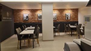 蔚山Hotel The Classic的用餐室设有桌椅和砖墙