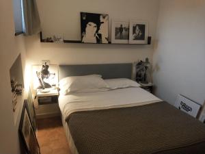 博格利斯科Bogliasco a due passi dal mare的一间卧室配有一张床和一张书桌,墙上挂有图片