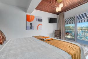 斯基亚索斯镇Megaron Skiathos Boutique Residence的一间带大床的卧室和一个阳台
