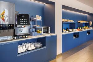 马德里B&B HOTEL Madrid Aeropuerto T1 T2 T3的一间拥有蓝色墙壁和食品柜台的面包店
