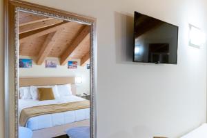 马格拉Atika & Atif - Hotel Autoespresso Venice的卧室内的镜子,配有一张床和电视