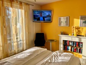 赛巴特班森Villa Marfa - FeWo 03的卧室配有一张床,墙上配有电视。