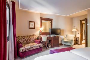 福米加尔Snö Villa de Sallent 4的酒店客房设有沙发椅和电视。