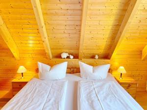 吕本瑙Ferienhaus Eisvogel的木制客房的一张床位,配有两个枕头