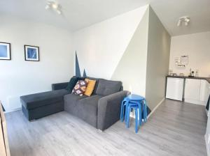 哈山Apartment in Hafjell / Øyer centre.的带沙发和蓝色凳子的客厅