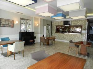 乔尔卢Sefa Hotel 2 Çorlu的一间设有钢琴和桌椅的餐厅
