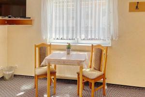 吕本瑙Ferienwohnung Hibiskus的窗户客房内的桌椅