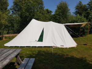 内斯Ameland tentenverhuur Ameland的野外的白色帐篷,配有野餐桌