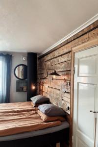 皮特奥Pensionatet的一间卧室设有木墙和一张带枕头的床。