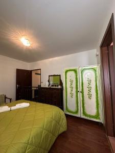 莫尔曼诺Lo Chalet della Principessa的一间卧室配有绿色的床和镜子