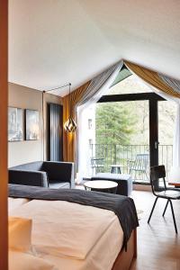 赫尔-格伦茨豪森Hotel Zugbrücke Grenzau GmbH的酒店客房设有一张床和一个阳台。