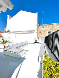 巴列塔圣帕特里克宾馆酒店的建筑里种植了植物的白色阳台